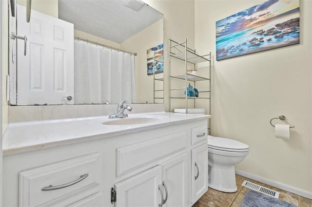 bathroom with vanity, a textured ceiling, and toilet