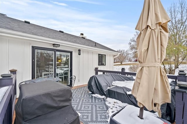 snow covered deck with a grill