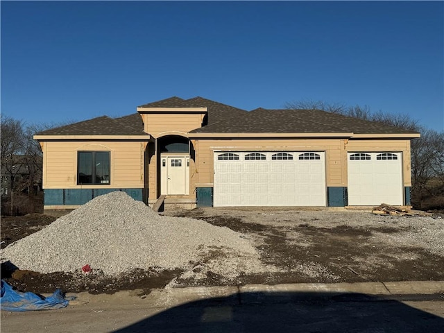 view of front of house with an attached garage and dirt driveway