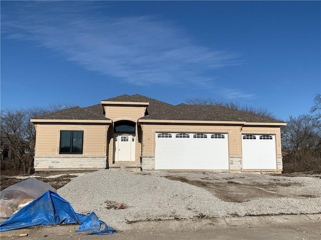 view of front of property with a garage, driveway, and stone siding