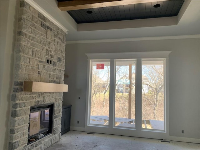 unfurnished living room featuring baseboards, a tray ceiling, a fireplace, wood ceiling, and crown molding