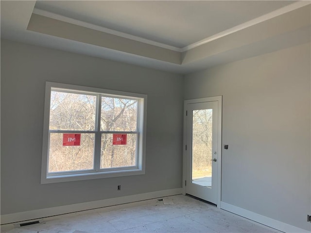 interior space featuring visible vents, baseboards, crown molding, and a tray ceiling