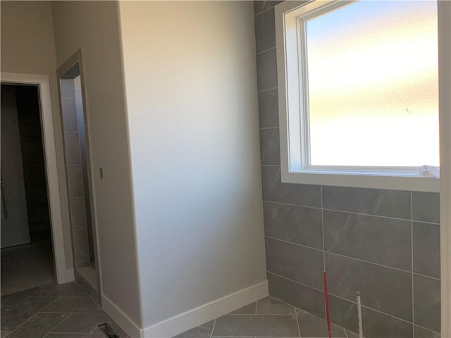 bathroom featuring tile patterned floors, baseboards, and walk in shower