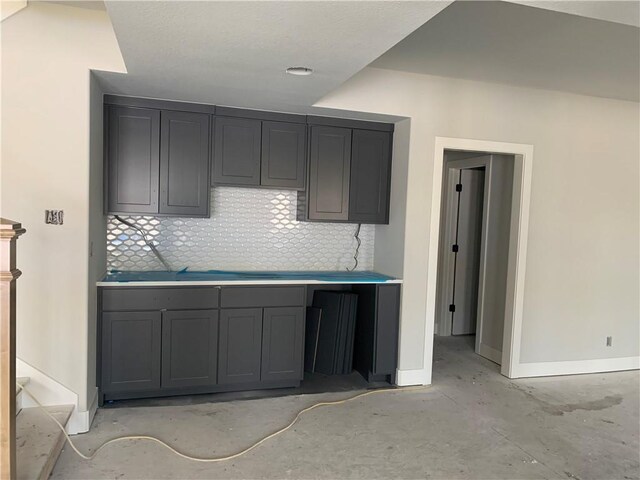 kitchen with decorative backsplash, baseboards, and gray cabinetry