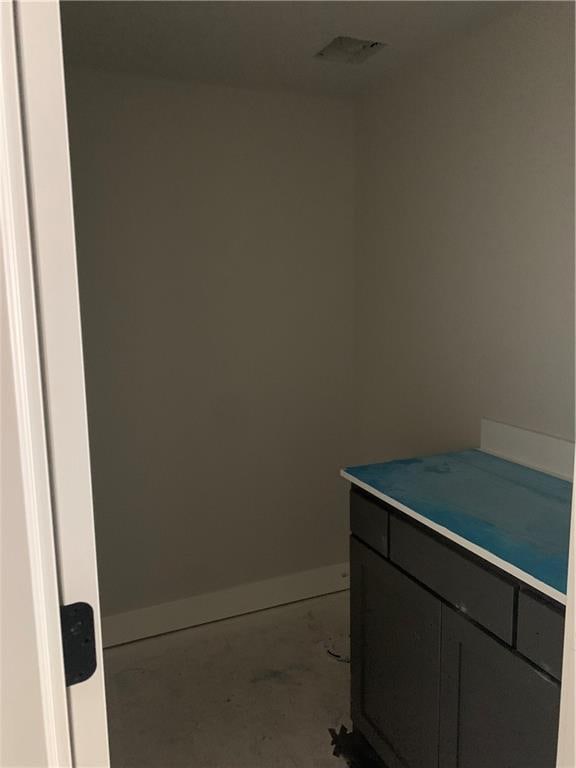 bathroom with visible vents, baseboards, concrete flooring, and vanity