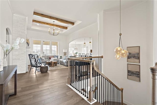 interior space featuring a notable chandelier, beamed ceiling, arched walkways, and wood finished floors