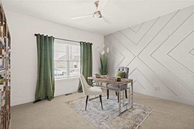 office area featuring visible vents, light carpet, baseboards, and a ceiling fan