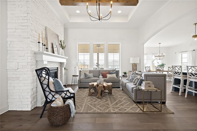 living room with a fireplace, wood finished floors, arched walkways, and a chandelier