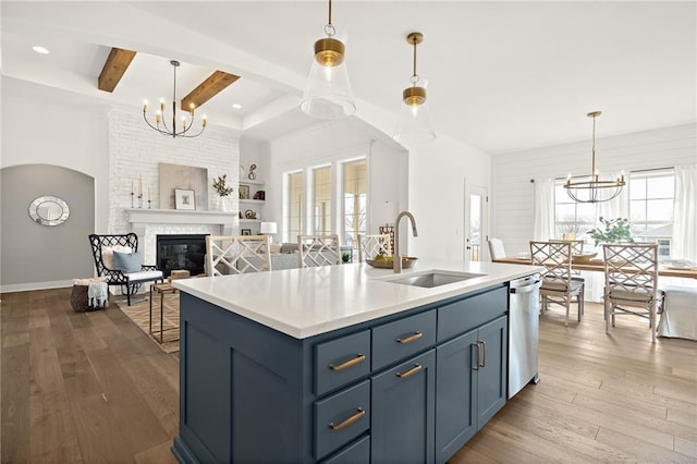 kitchen with a sink, wood-type flooring, dishwasher, and a chandelier