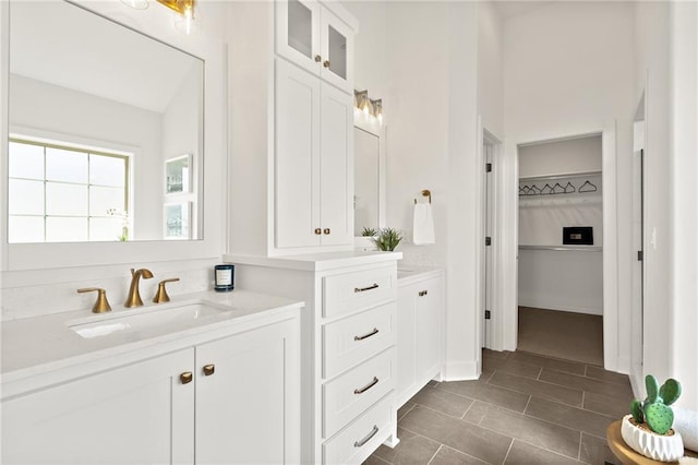 full bathroom with vanity, a spacious closet, and tile patterned flooring