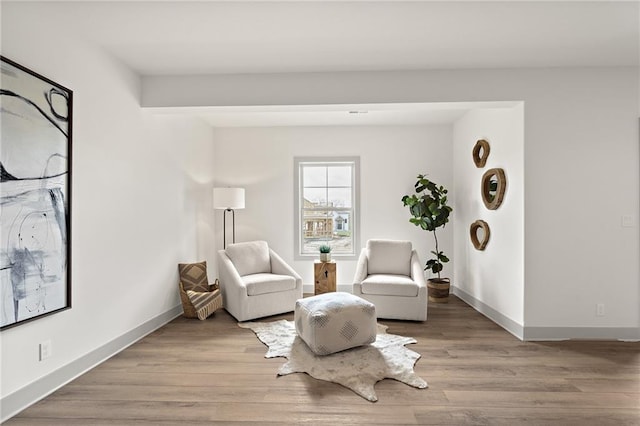 sitting room featuring baseboards and light wood-style flooring