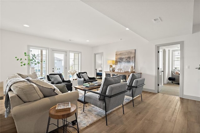 living room with plenty of natural light, recessed lighting, visible vents, and light wood-style floors