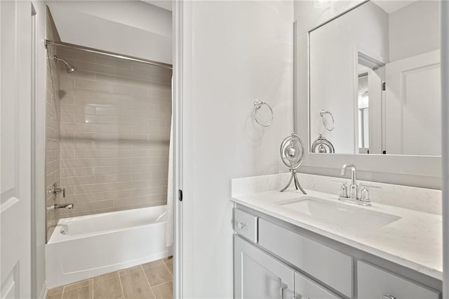 bathroom featuring wood finish floors, shower / washtub combination, and vanity