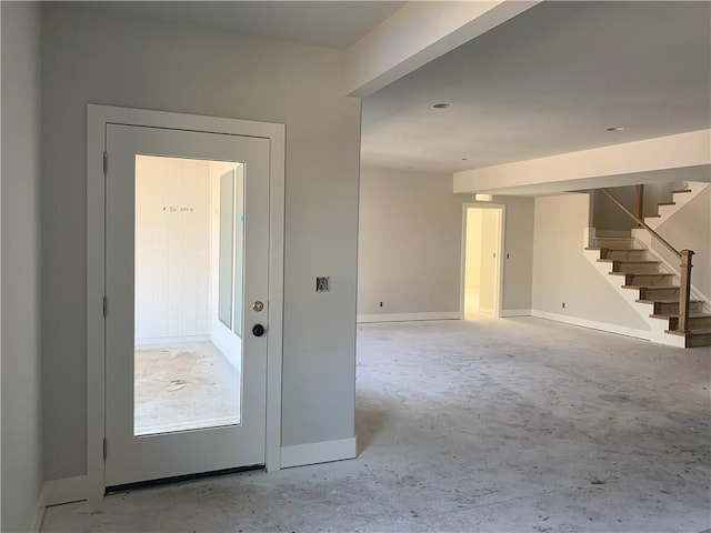 interior space with stairway, baseboards, and unfinished concrete floors