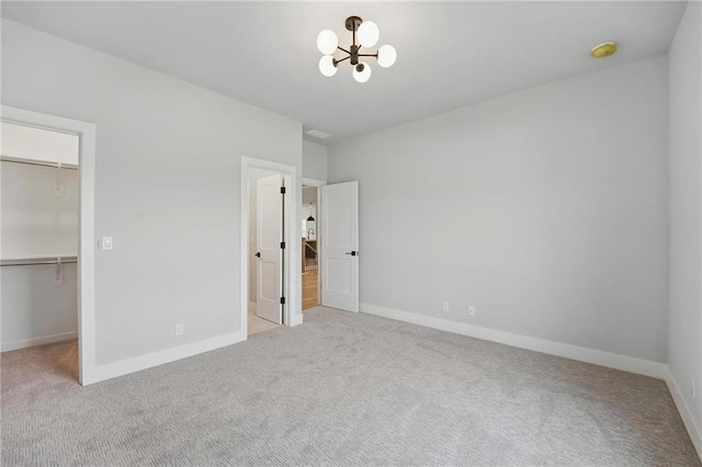 1406 NW 106th Ter, Kansas City, MO 64155 - unfurnished bedroom with a walk in closet, carpet, a chandelier, and a closet