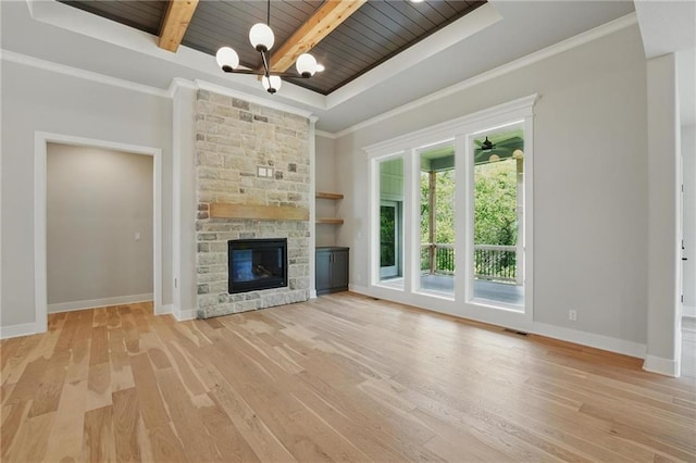 1406 NW 106th Ter, Kansas City, MO 64155 - unfurnished living room featuring a wooden ceiling with exposed beams, light wood-type flooring, a stone fireplace, a chandelier, and a raised ceiling