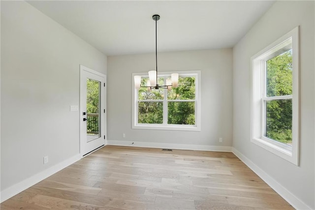 1406 NW 106th Ter, Kansas City, MO 64155 - unfurnished dining area featuring healthy amount of natural light, a chandelier, and light wood-style flooring
