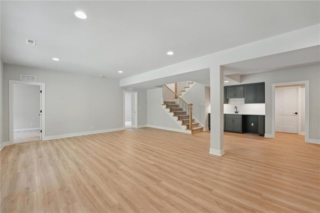 1406 NW 106th Ter, Kansas City, MO 64155 - unfurnished living room featuring stairs, recessed lighting, and light wood-style floors