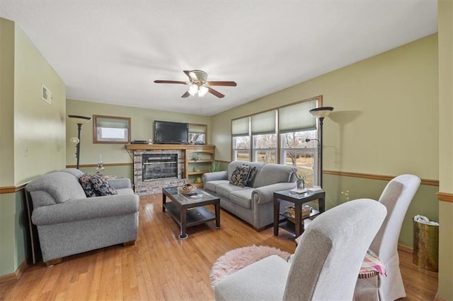 living area featuring visible vents, plenty of natural light, and wood finished floors