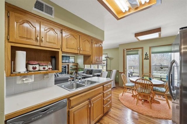 kitchen featuring visible vents, light wood-type flooring, light countertops, stainless steel appliances, and a sink