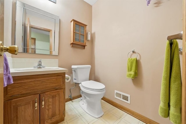 bathroom with visible vents, baseboards, toilet, tile patterned floors, and vanity