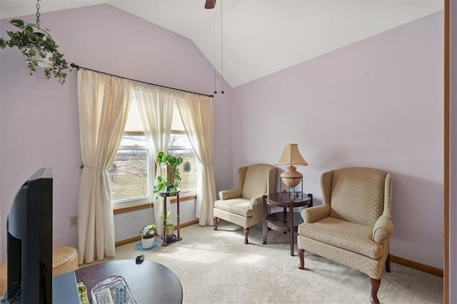 sitting room featuring baseboards, lofted ceiling, and carpet