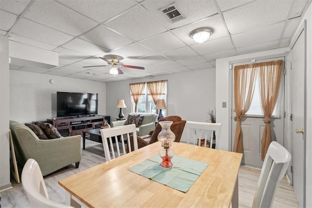 dining room with visible vents, a paneled ceiling, light wood-style floors, and ceiling fan