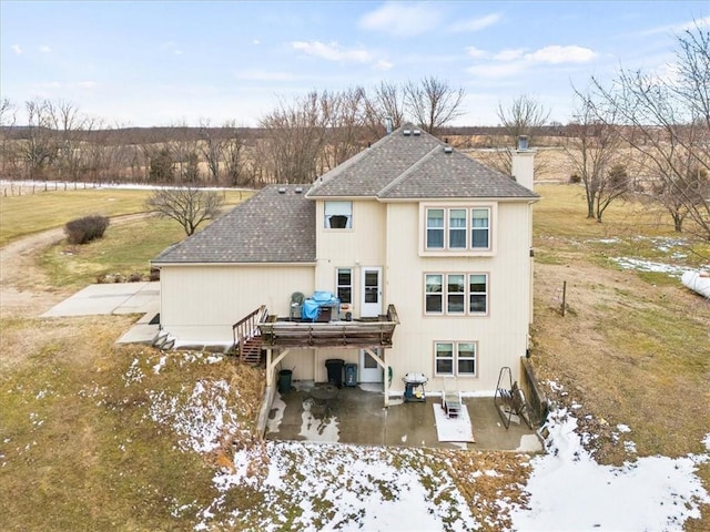 rear view of property featuring a shingled roof, central AC unit, a patio area, and a chimney