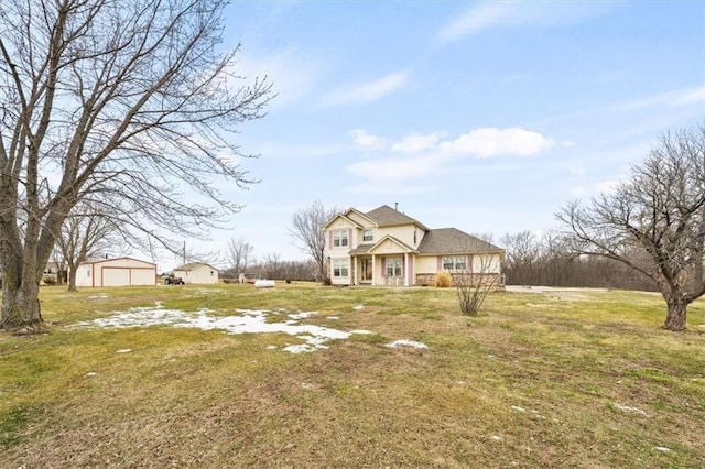 view of front facade featuring a detached garage, a front lawn, and an outdoor structure