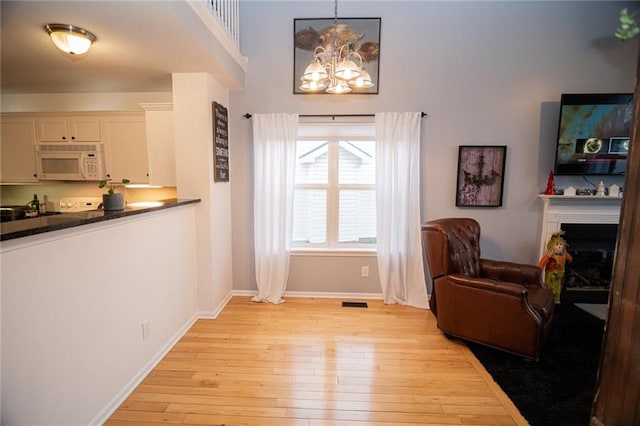 living area featuring a chandelier and light hardwood / wood-style flooring