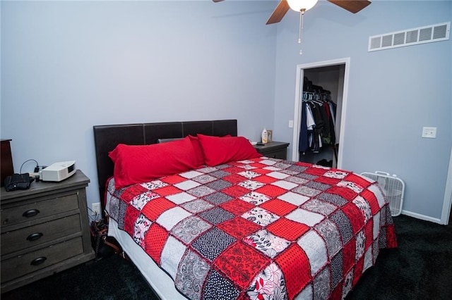 carpeted bedroom with a spacious closet, ceiling fan, and a closet