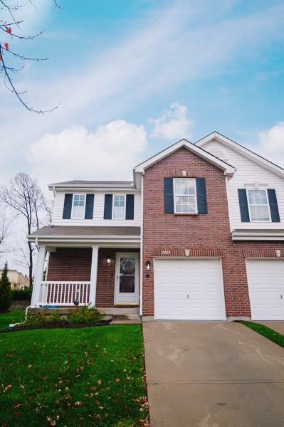 view of front facade featuring a garage, a front yard, and covered porch