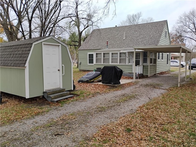 rear view of property featuring a storage unit