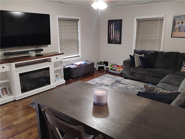 living room with ceiling fan and dark wood-type flooring