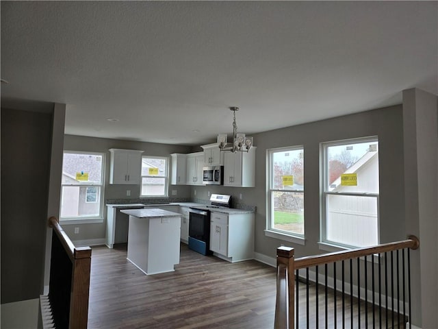 kitchen featuring a center island, dark wood-type flooring, white cabinets, decorative light fixtures, and electric range oven