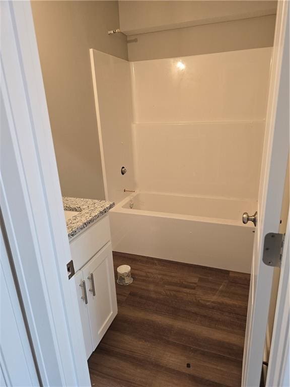 bathroom with hardwood / wood-style floors, vanity, and shower / bathtub combination