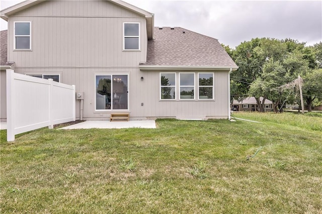 rear view of property featuring a lawn and a patio area