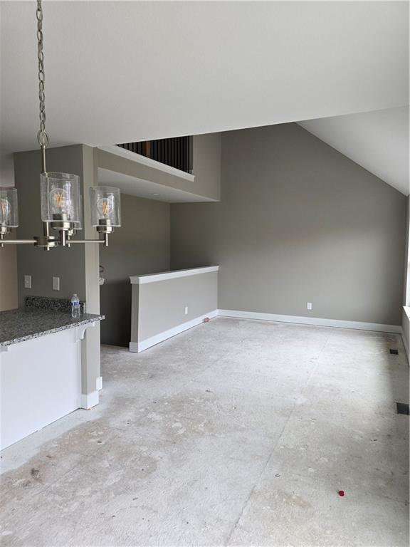 unfurnished living room featuring vaulted ceiling