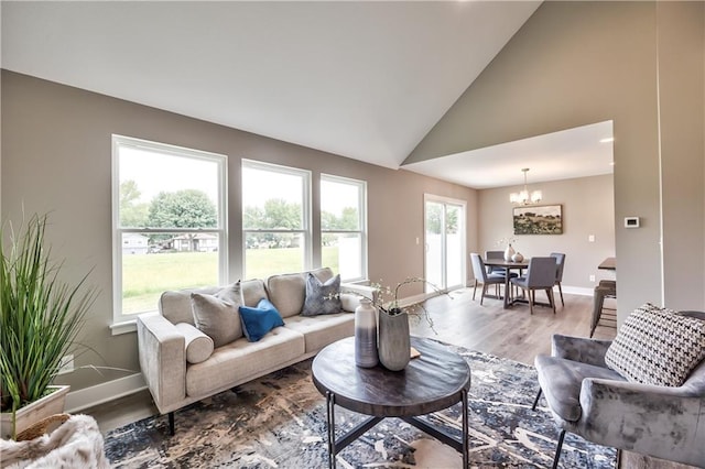 living room featuring hardwood / wood-style floors, a notable chandelier, and high vaulted ceiling