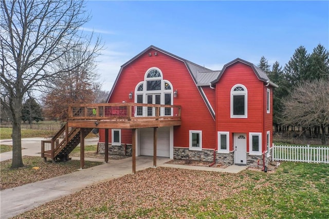 rear view of property featuring a garage and a deck