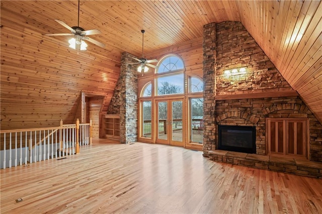 unfurnished living room with high vaulted ceiling, wooden ceiling, and wood walls