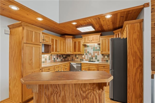 kitchen with a kitchen breakfast bar, decorative backsplash, sink, and stainless steel appliances