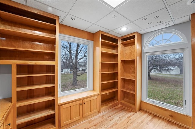 interior space with a paneled ceiling and light hardwood / wood-style flooring