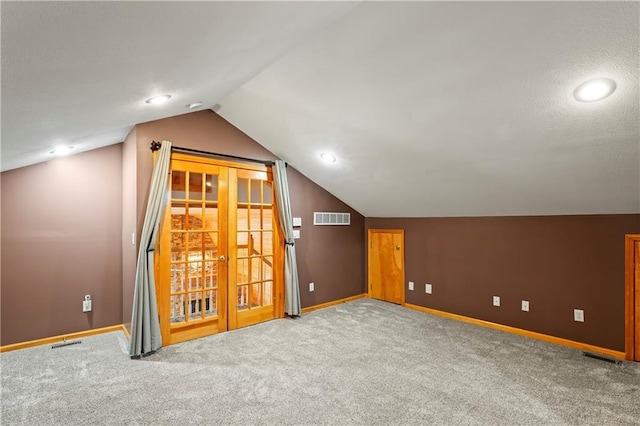 additional living space with french doors, carpet floors, and lofted ceiling