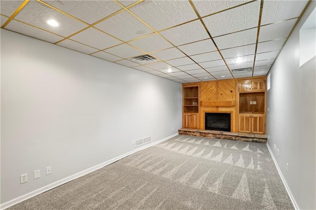 unfurnished living room featuring carpet flooring and a paneled ceiling