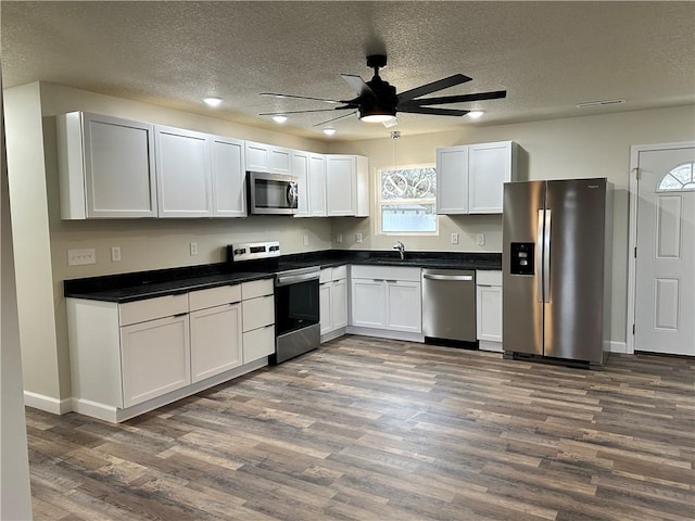 kitchen featuring dark wood-type flooring, sink, white cabinets, and stainless steel appliances