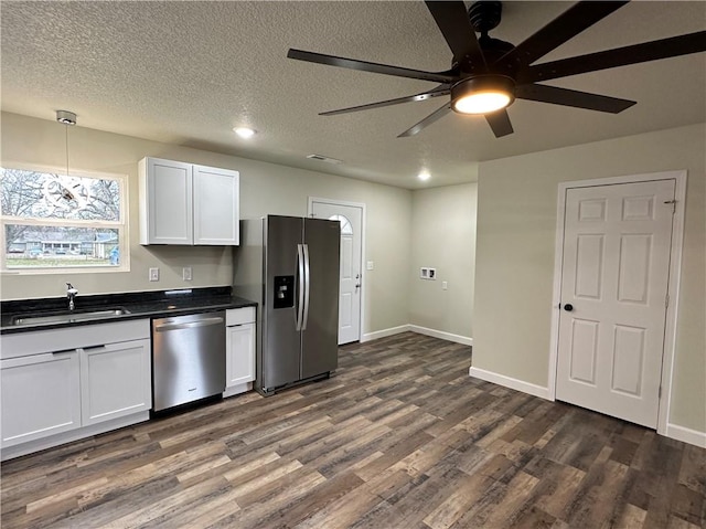 kitchen featuring ceiling fan, sink, dark wood-type flooring, stainless steel appliances, and white cabinets