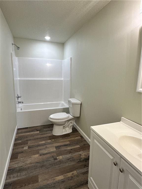 full bathroom with vanity, bathtub / shower combination, hardwood / wood-style flooring, toilet, and a textured ceiling