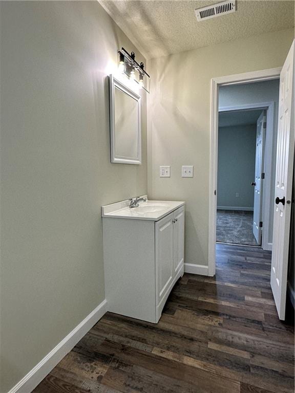 bathroom with vanity, wood-type flooring, and a textured ceiling