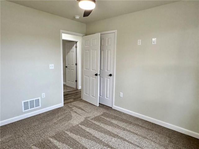 unfurnished bedroom featuring carpet floors, a closet, and ceiling fan